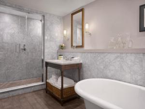 ein Bad mit einer Badewanne, einem Waschbecken und einer Dusche in der Unterkunft InterContinental Hotels - Edinburgh The George, an IHG Hotel in Edinburgh
