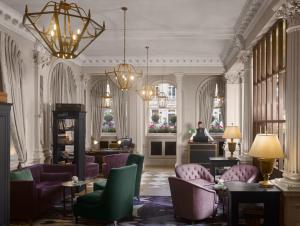 a lobby with purple chairs and a woman standing in a room at InterContinental Edinburgh The George, an IHG Hotel in Edinburgh