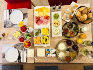 a wooden table topped with different types of food at Bayern Resort Hotel - Adults only - mit Zugspitzblick - Eibsee-Nähe - Wellnessbereich - Naturpool im Sommer in Grainau