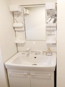 a bathroom with a white sink and a mirror at ピオーレ大手門501 in Susakiuramachi