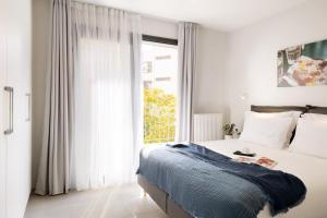 塞萨洛尼基Thess Residences的一间卧室，里面有一张床和一扇大窗户。