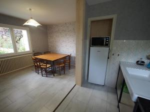 a kitchen and dining room with a table and a refrigerator at Escale en Revermont in Saint-Lothain