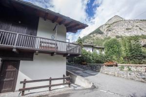 ein Gebäude mit einem Balkon auf der Seite in der Unterkunft ALTIDO Idyllic Flat for 7 with Free Parking Close to Ski Lift in Courmayeur