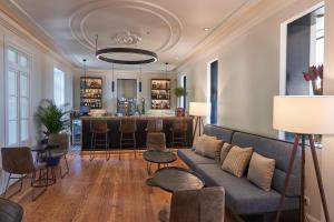 a living room with a couch and a bar at Les Suites at The Cliff Bay - PortoBay in Funchal