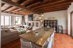 a kitchen and living room with a large wooden table at De Bosrand in Ichtegem