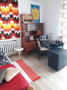 Modern retro apartament Katowice في كاتوفيسي: غرفة نوم مع مكتب ومكتب مع مكتب