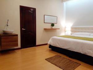 una camera con letto e un bagno con lavandino di Casa D´Cristhi a Puerto Baquerizo Moreno