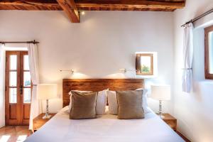 a room with a bed, a table and a window at Agroturismo Atzaró in Santa Eularia des Riu