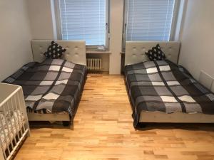 2 Betten in einem Zimmer mit Holzböden und Fenstern in der Unterkunft Ferienwohnung Amperblick Fürstenfeldbruck in Fürstenfeldbruck