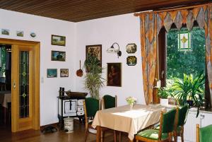 a dining room with a table and green chairs at Hartlef´s Gasthof in Stade