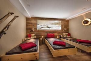 two beds in a room with wooden walls at Bayern Resort Hotel - Adults only - mit Zugspitzblick - Eibsee-Nähe - Wellnessbereich - Naturpool im Sommer in Grainau