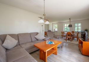 ein Wohnzimmer mit einem Sofa und einem Tisch in der Unterkunft Bibis Hus in Pellworm