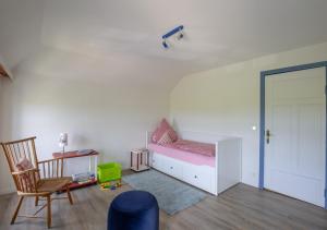 ein Kinderzimmer mit einem rosa Bett und einem Stuhl in der Unterkunft Bibis Hus in Pellworm