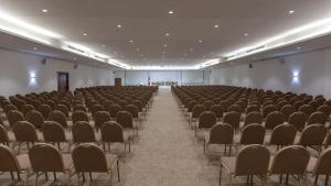 an empty room with rows of chairs and a stage at Hotel Nour Congress & Resort in Bizerte