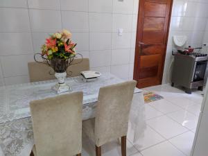 una mesa de comedor con un jarrón de flores. en Casa 1/4 Chapada Diamantina/ibicoara en Ibicoara