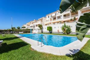 a swimming pool in front of a building at Apartamento Montesol 80 in Torrox Costa
