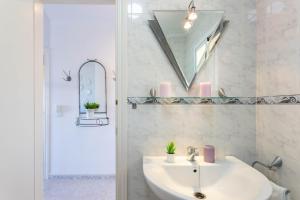 a white bathroom with a sink and a mirror at Apartamento Montesol 80 in Torrox Costa +53 photos