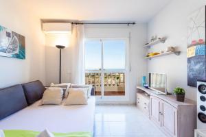 a living room with a couch and a television at Apartamento Montesol 80 in Torrox Costa