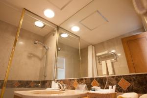 
a bathroom with a shower, sink, and mirror at Hotel Mt. Fuji in Yamanakako
