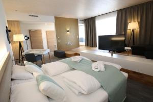 a hotel room with a large bed and a television at Donau Lodge in Ybbs an der Donau