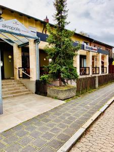 ein Gebäude mit einem Baum vor einer Straße in der Unterkunft Akropolis Hotel in Nürnberg