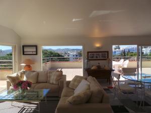 een woonkamer met 2 banken en een glazen tafel bij Spacious and bright flat Downtown and Beaches - Swimming Pool in Antibes