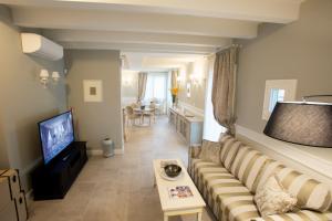 a living room with a couch and a television at Villa Pergola by Palazzo di Varignana in Varignana