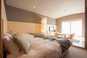 a bedroom with a large bed and a dining room at Hotel Mt. Fuji in Yamanakako