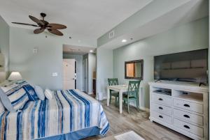 a bedroom with a bed and a dresser and a table at Sandestin Resort Luau by Tufan in Destin