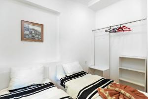a bedroom with two beds and a picture on the wall at 31 Toidze Apartment in Tbilisi City