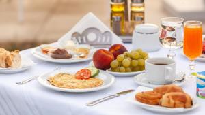 a table with plates of breakfast food and drinks at Hotel Nour Congress & Resort in Bizerte