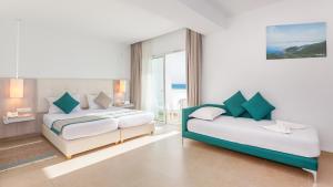 a hotel room with two beds and a balcony at Hotel Nour Congress & Resort in Bizerte