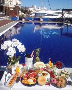 a table topped with plates of food and flowers at Port Salins in Empuriabrava