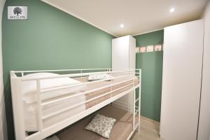 a small bedroom with green walls and white bunk beds at La VILLA in Modugno