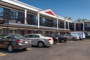 a group of cars parked in a parking lot in front of a building at Carlton Inn Midway in Chicago