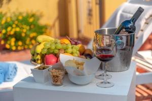 un tavolo con un bicchiere di vino e un cesto di frutta di Locanda Sant'Andrea Hotel & Relais a San Pantaleo