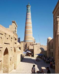 a lighthouse in the middle of a city with a building at Mubina Khiva B&B in Khiva