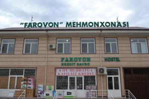 a building with a sign on the top of it at hostel Farovon in Margilan
