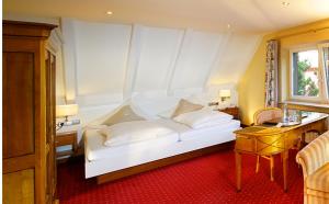 Cama blanca en habitación con ventana en Hotel Rebstock Durbach, en Durbach