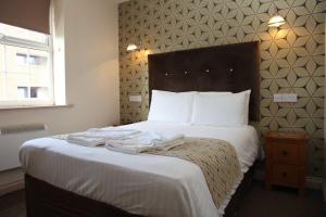 a bed in a hotel room with towels on it at The Moseley Arms in Birmingham