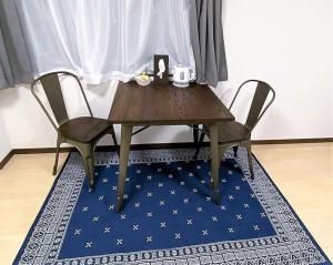 熊本的住宿－002.Standard Number，一张带两把椅子的木桌和蓝色地毯