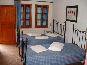 two twin beds in a room with two windows at Dina Studio Maisonettes in Platanias