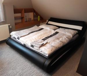 a bed with a black frame in a room at Apartmán Lidická in Vracov