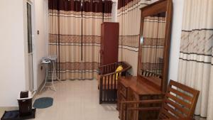 a room with a crib and a hallway with curtains at Risenlak Holiday Resort in Polonnaruwa
