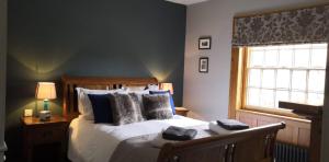 a bedroom with a bed with pillows and a window at The Three Horseshoes in Warham