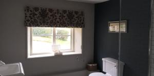 a bathroom with a window and a white toilet at The Three Horseshoes in Warham
