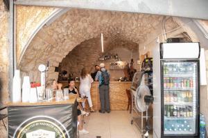 a group of people standing at a bar in a store at La Casetta in Nazareth