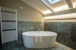 a bath tub in a bathroom with a skylight at Villa Pergola by Palazzo di Varignana in Varignana +36 photos