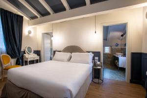a bedroom with a large white bed and a bathroom at Villa Pergola by Palazzo di Varignana in Varignana