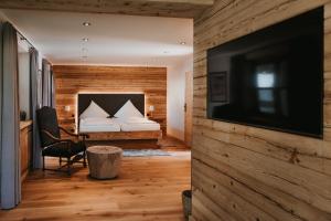 Schlafzimmer mit einem Bett und einem Flachbild-TV in der Unterkunft Tegernseer Hof in Gmund am Tegernsee